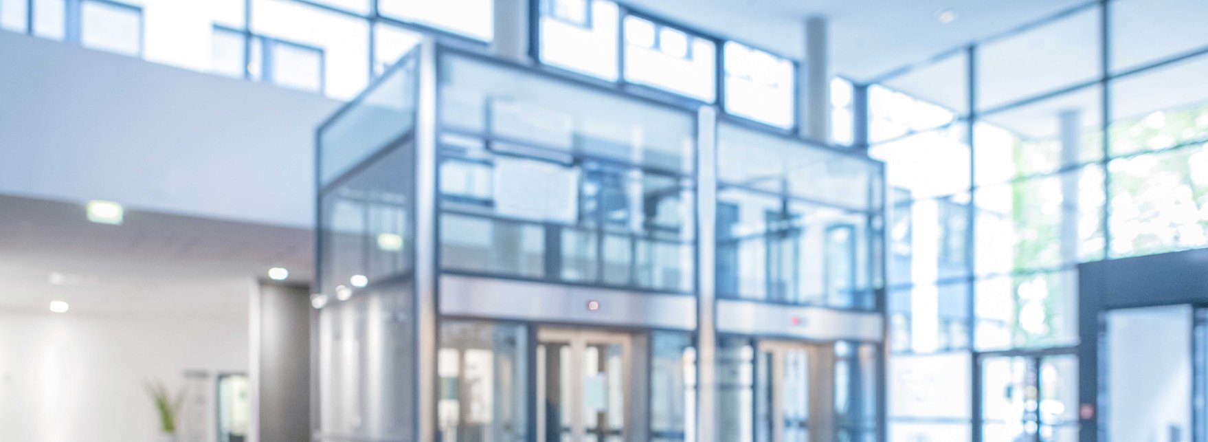 Kontakt | Guntermann Rechtsanwälte unscharfe Innenansicht der Glasfront eines Gebäudes